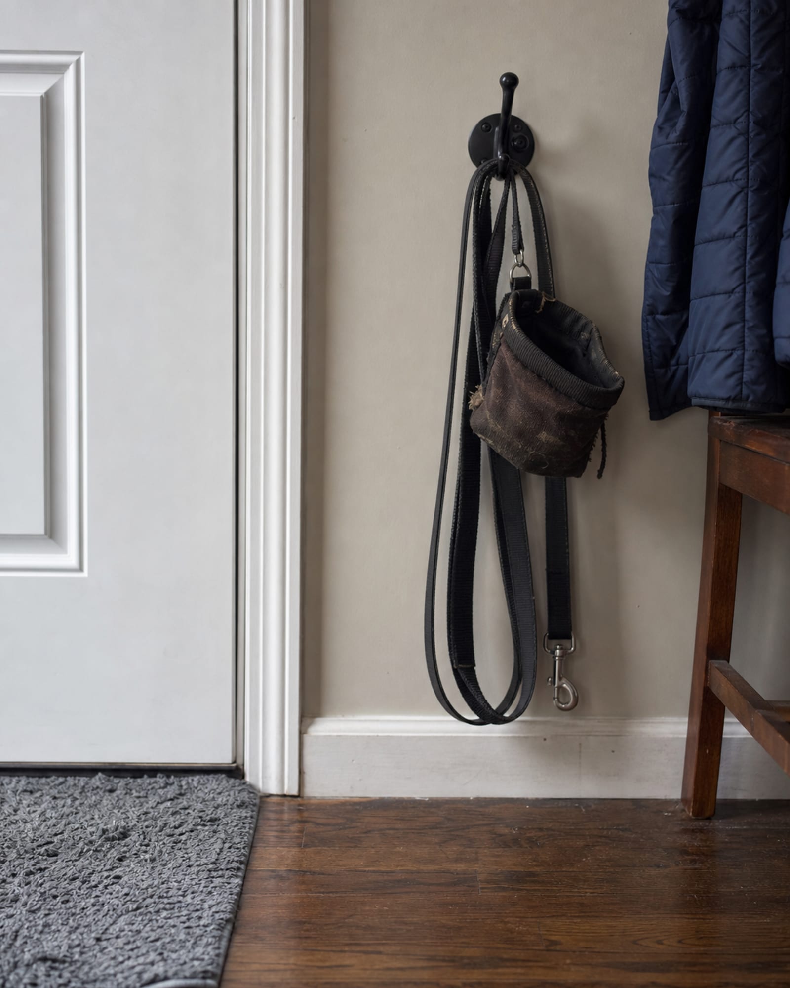 A lead coiled on a hook by a door, no dog in frame